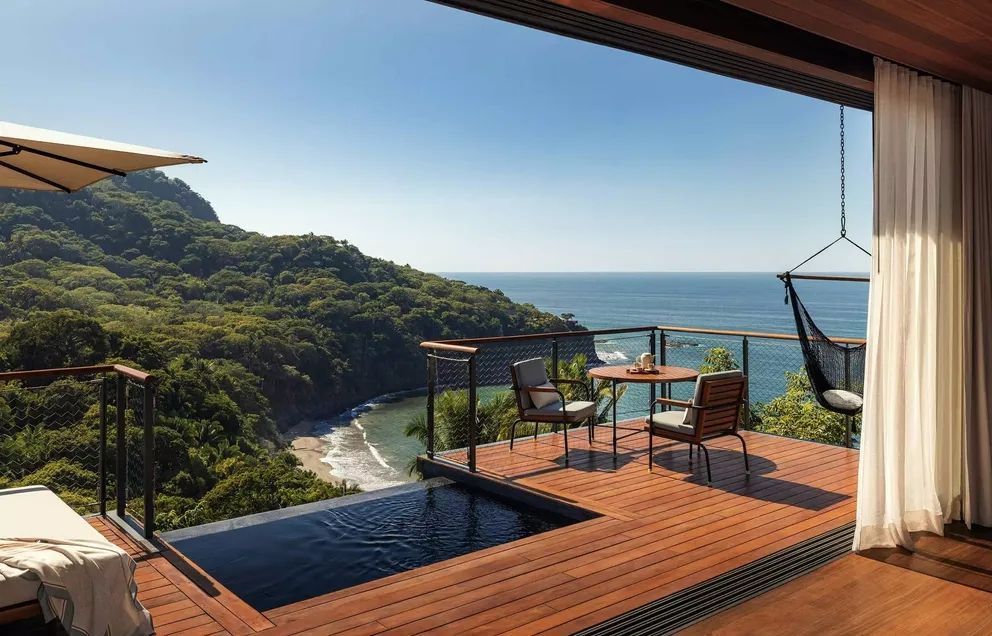 Atemberaubende Terrasse mit Pool und Blick auf den tropischen Strand.