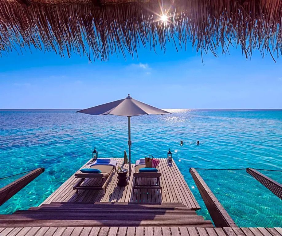 Sonnenliegen auf der privaten Terrasse über dem Meer mit Sonnenschirm