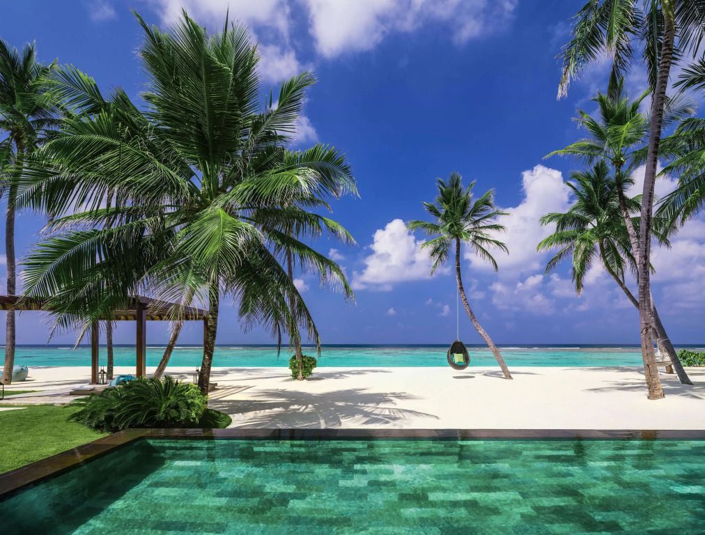 Unberührter Strand mit Palmen und Blick auf türkisblaues Meer