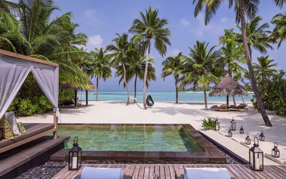 Privater Pool der Villa mit Blick auf Palmen und den Strand