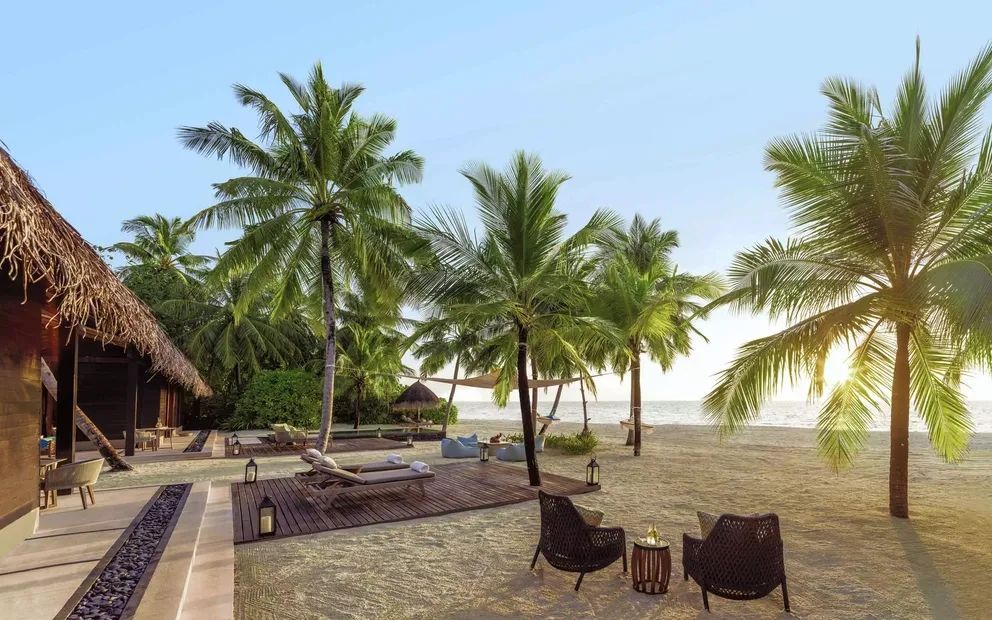 Strandbereich mit Palmen, Liegen und Sesseln am One&Only Reethi Rah
