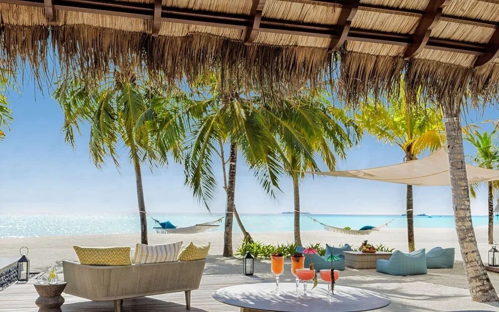 Outdoor-Lounge mit Cocktails und Hängematten zwischen Palmen am Strand