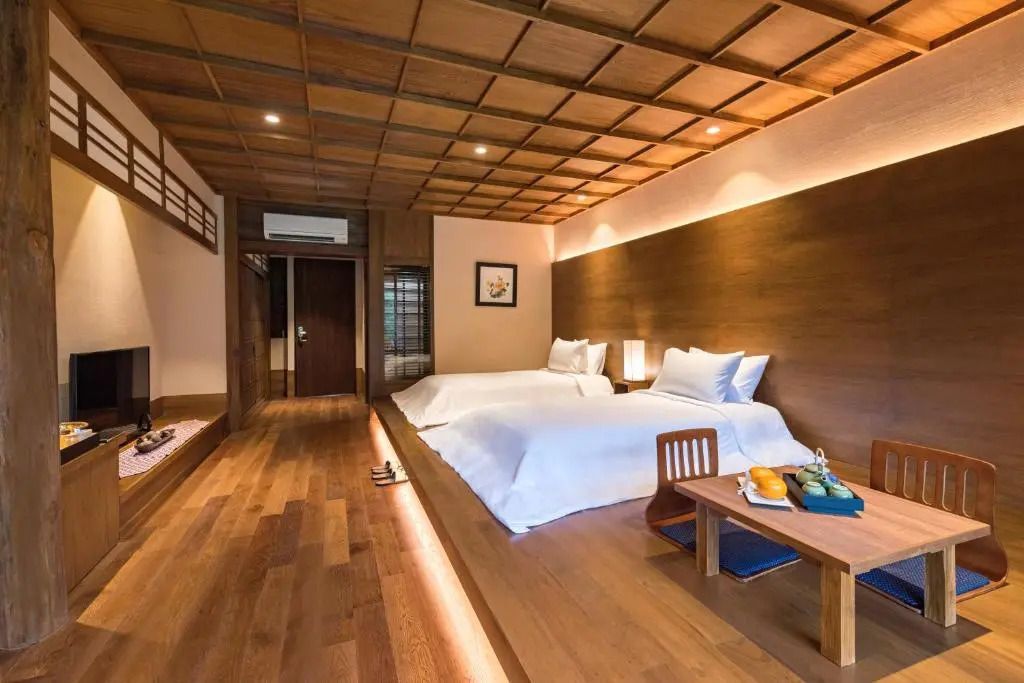 Holzvertäfeltes Zimmer mit zwei Betten und traditionellem Dekor