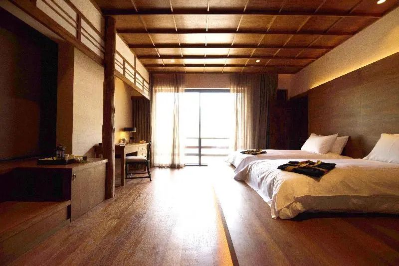 Helles Zimmer mit großem Bett und japanischen Designelementen