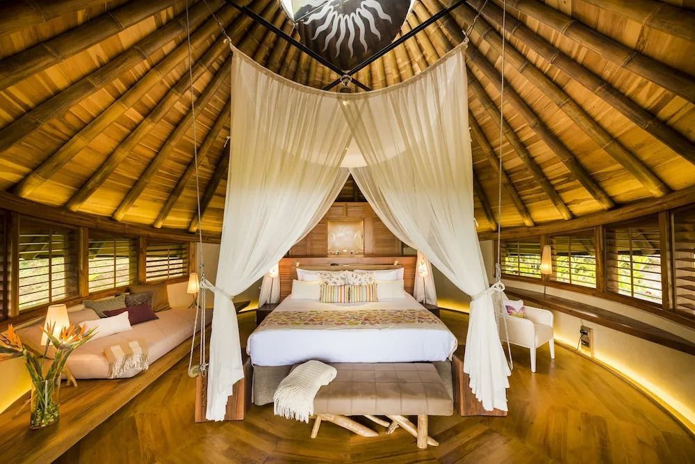 Luxuriöses Zimmer mit Baldachinbett und Holzdach in einer Lodge
