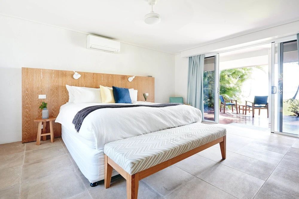 Helles Strandzimmer mit modernem Bett und Zugang zur Terrasse