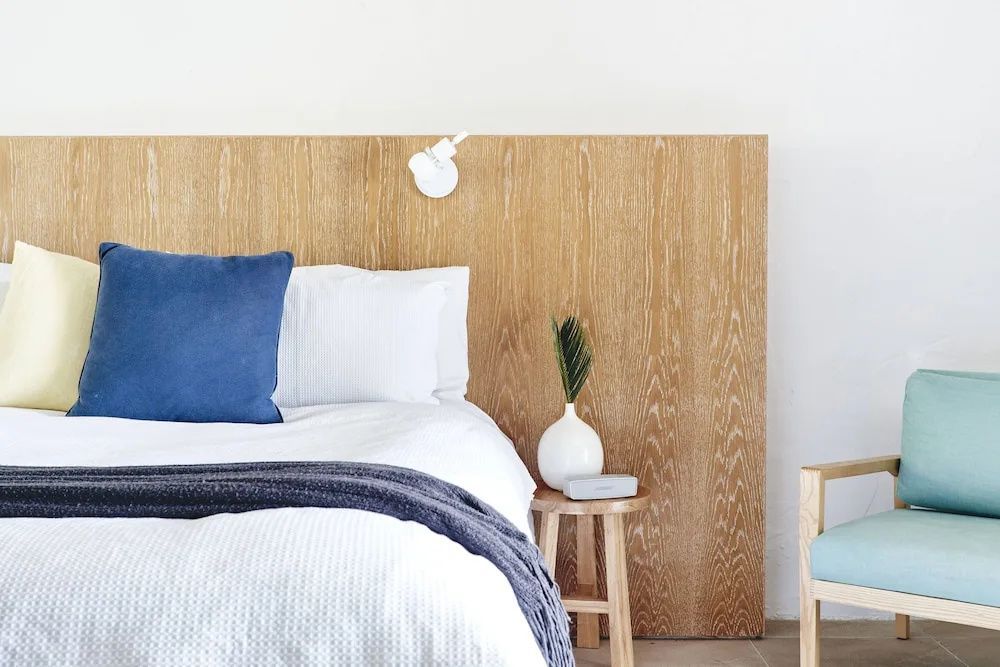 Gemütliches Bett mit Holzkopfteilen und Dekoration