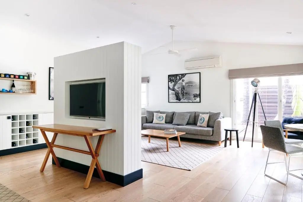 Offener Wohnbereich mit Fernseher, Tisch und hellem, freundlichem Interieur