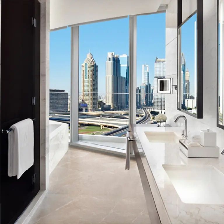 Modernes Badezimmer mit Fensterblick auf die Wolkenkratzer von Dubai.