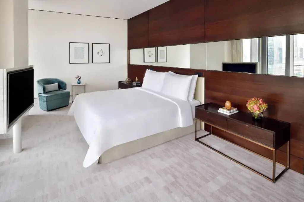 Elegantes Doppelbett in moderner Suite mit hellen Farben und schicker Einrichtung.