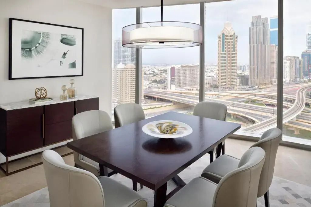 Essbereich mit Tisch und Stühlen, großer Fensterblick auf die Skyline von Dubai.
