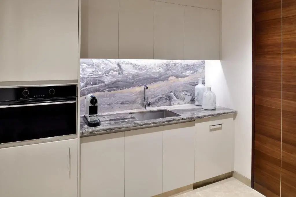 Moderne Küchenzeile mit eleganter Steinverkleidung und hochwertigen Geräten.