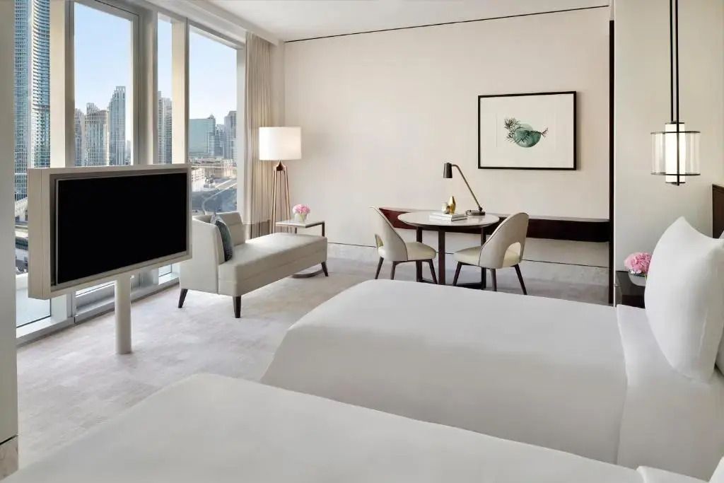 Geräumiges Hotelzimmer mit stilvollem Sitzbereich und zwei Einzelbetten.