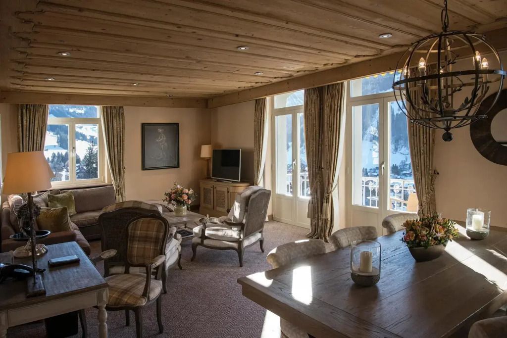 Sonnendurchfluteter Wohnraum mit Polstermöbeln und großen Fenstern im alpinen Stil