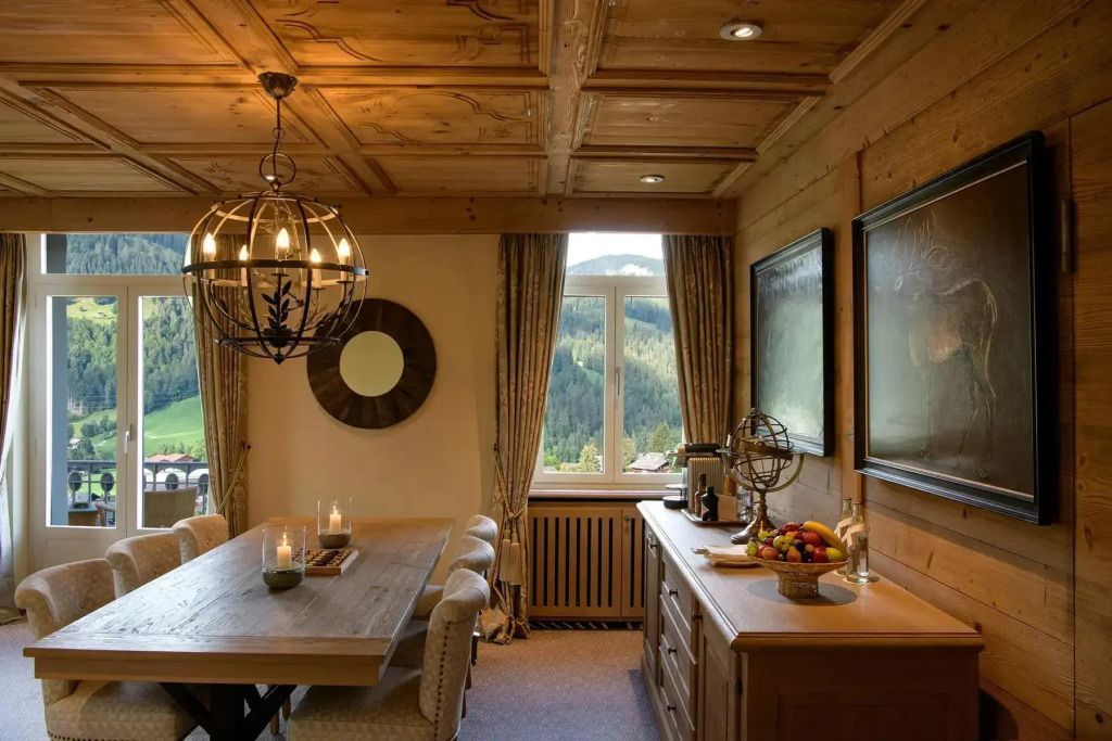 Essbereich der Suite mit Holzmöbeln und Blick auf die bewaldeten Berge