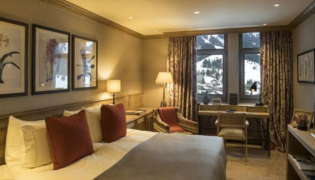 Gemütliches Schlafzimmer mit Doppelbett und Bergblick durch große Fenster