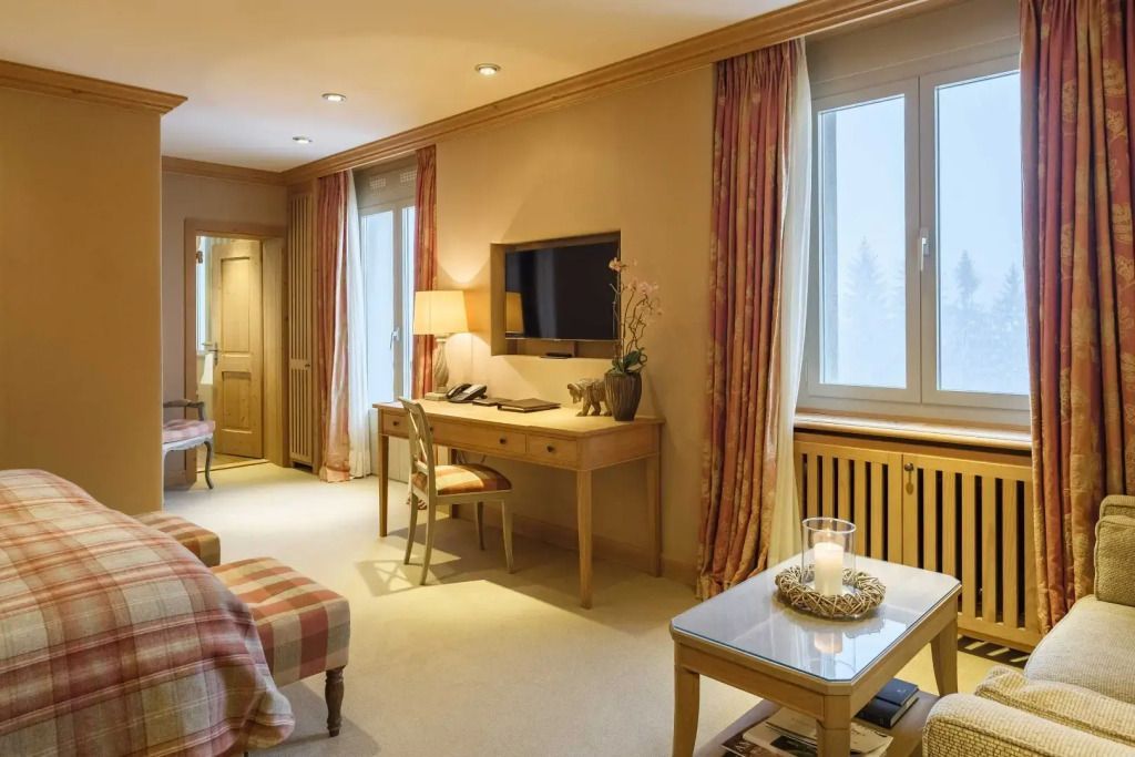 Suite mit Schreibtisch, bequemer Sitzgelegenheit und großer Fensterfront.