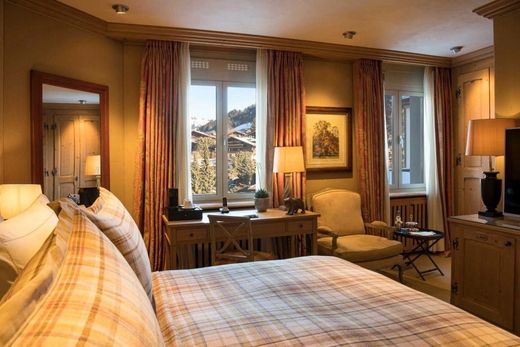 Doppelbettzimmer mit warmer Beleuchtung und Blick auf verschneite Berge