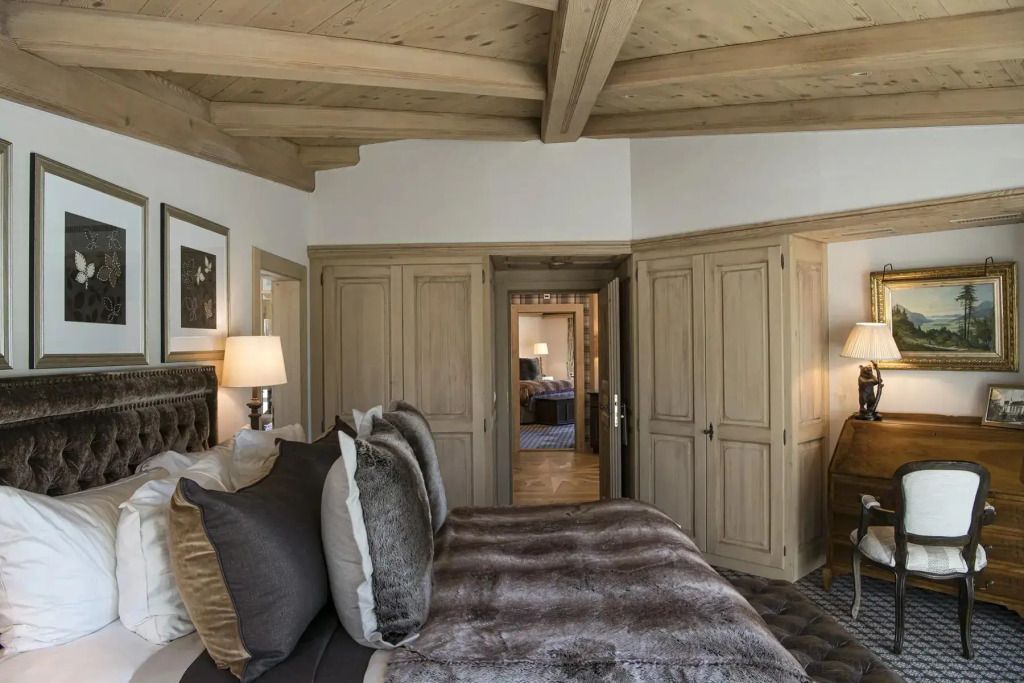 Geräumiges Schlafzimmer mit luxuriöser Einrichtung und Holzbalkendecke.