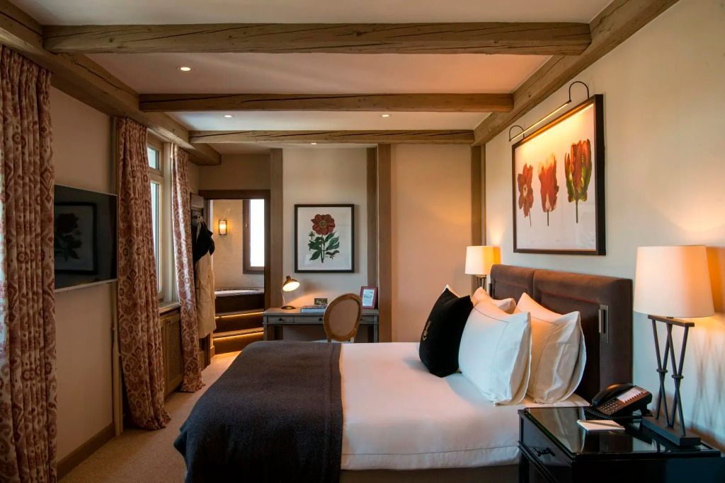 Gemütliches Schlafzimmer mit Kunstwerken und Holzbalken in der Tower Junior-Suite.