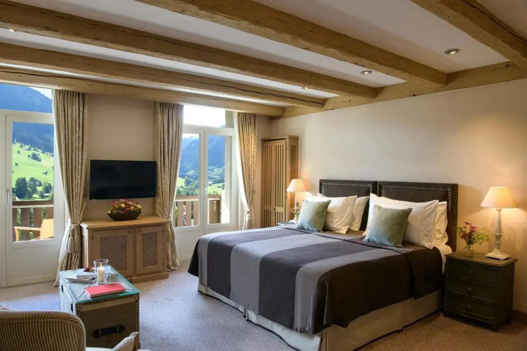 Gemütliches Schlafzimmer mit Holzbalken und Aussicht auf die Berge