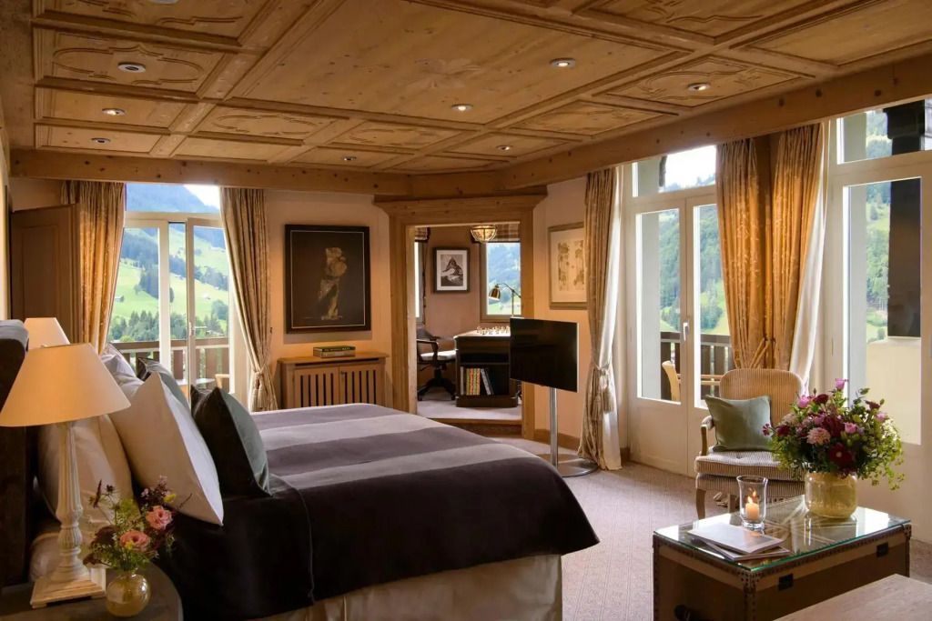 Luxuriöse Suite mit Holzelementen und Balkonblick auf die Landschaft