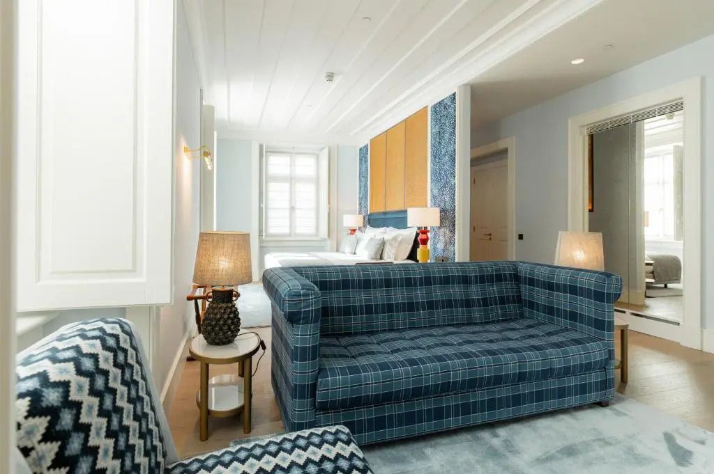 Junior-Suite mit blauer Couch und gemütlichem Wohnbereich in edlem Design.