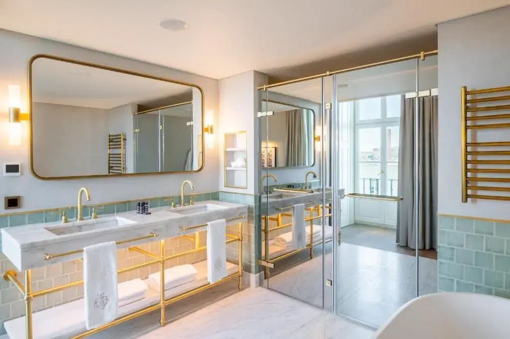 Modernes Badezimmer mit Doppelwaschbecken und goldenen Akzenten