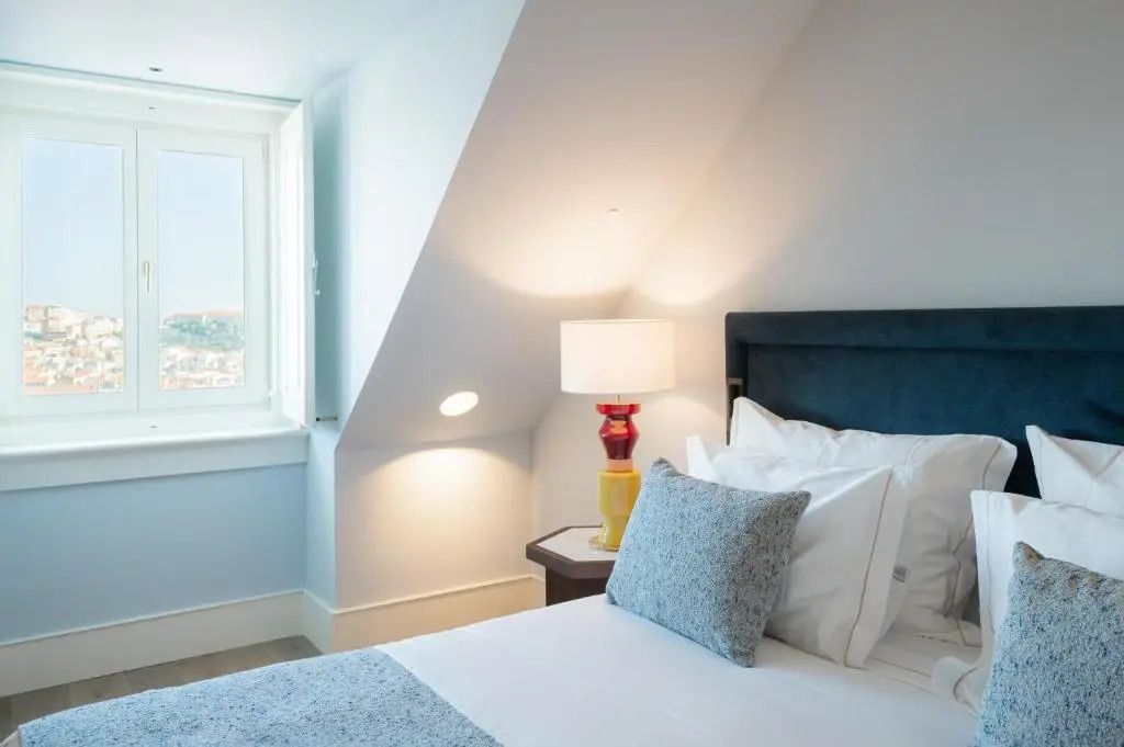 Hotelzimmer mit gemütlichem Bett und Blick aus dem Fenster auf die Stadt