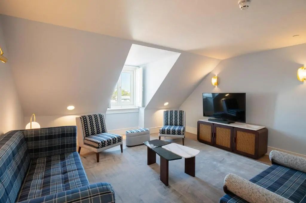 Geräumiger Wohnbereich der Suite mit TV und stilvollen Sesseln