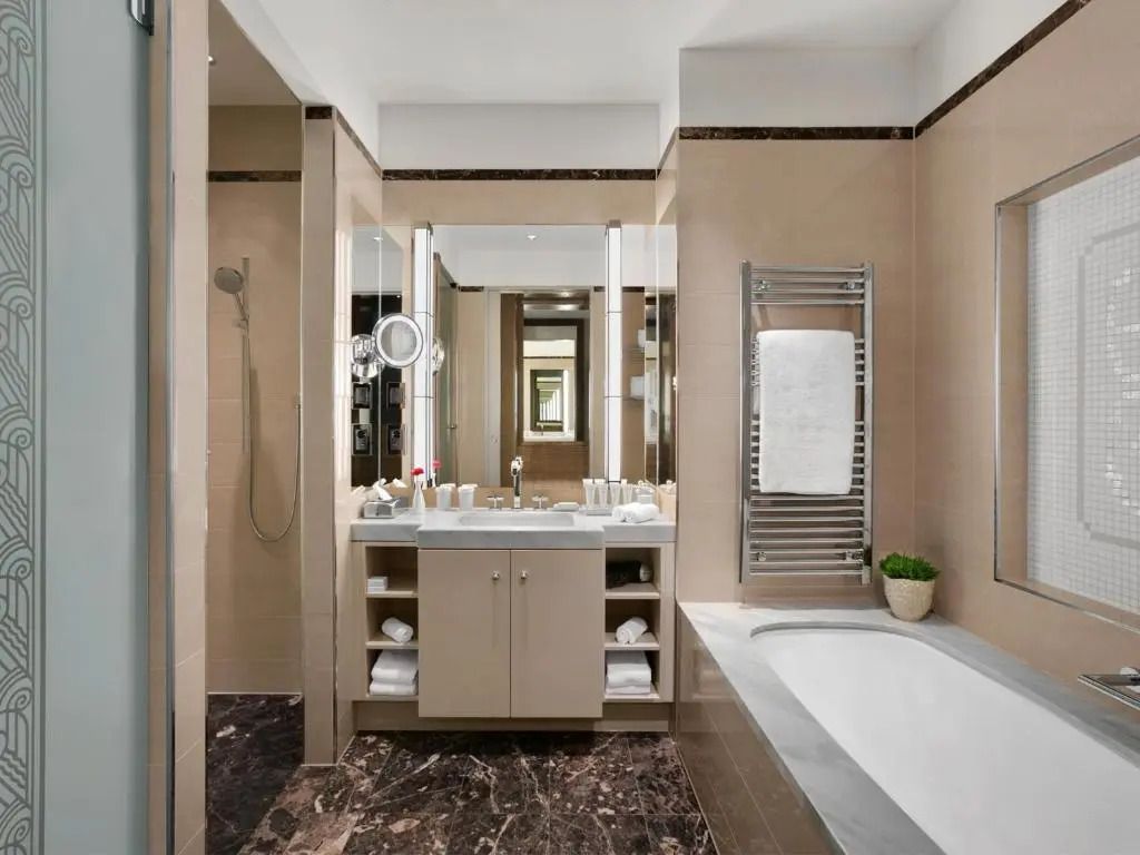 Modernes Badezimmer mit großer Badewanne und Marmorfliesen in der Junior-Suite