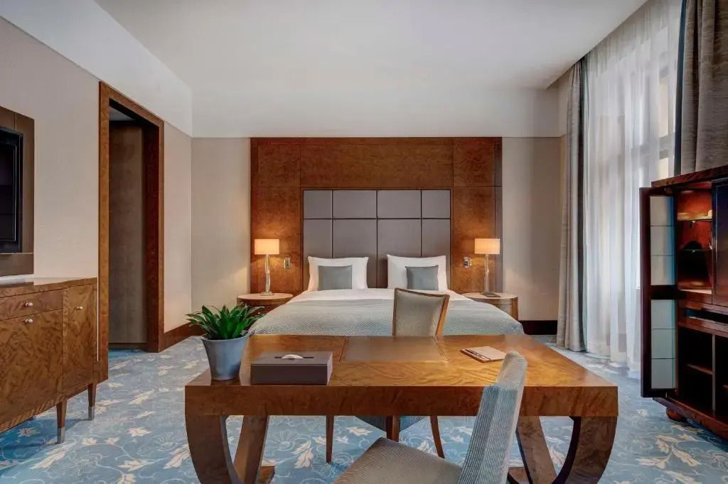 Junior-Suite mit großem Doppelbett und dekorativem Holzmöbel