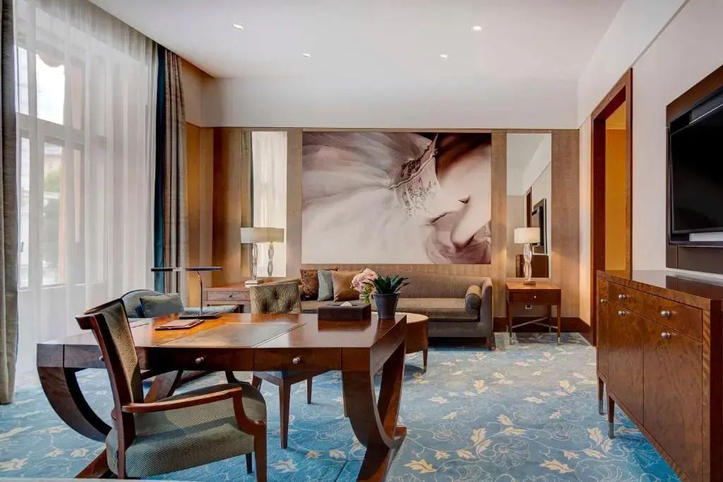 Wohnbereich der Junior-Suite mit stilvollen Möbeln und großer Kunst an der Wand