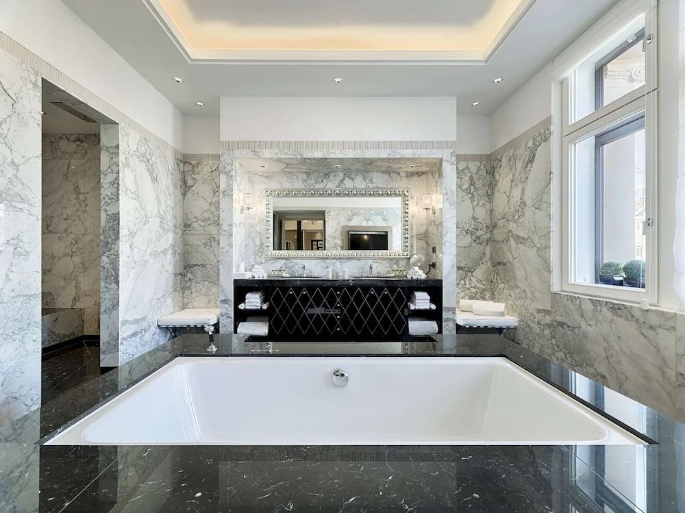 Luxuriöses Badezimmer mit Marmordekor und großer Badewanne