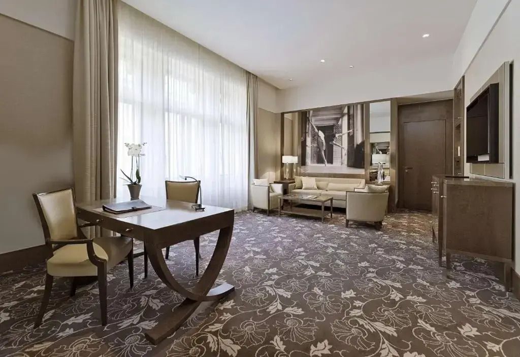Helles Wohnzimmer der Premium Suite mit stilvollen Möbeln und großer Fensterfront.