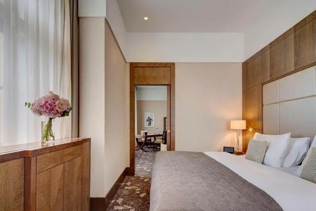 Elegantes Schlafzimmer in der Premium Suite mit großen Fenstern und edlem Bett.