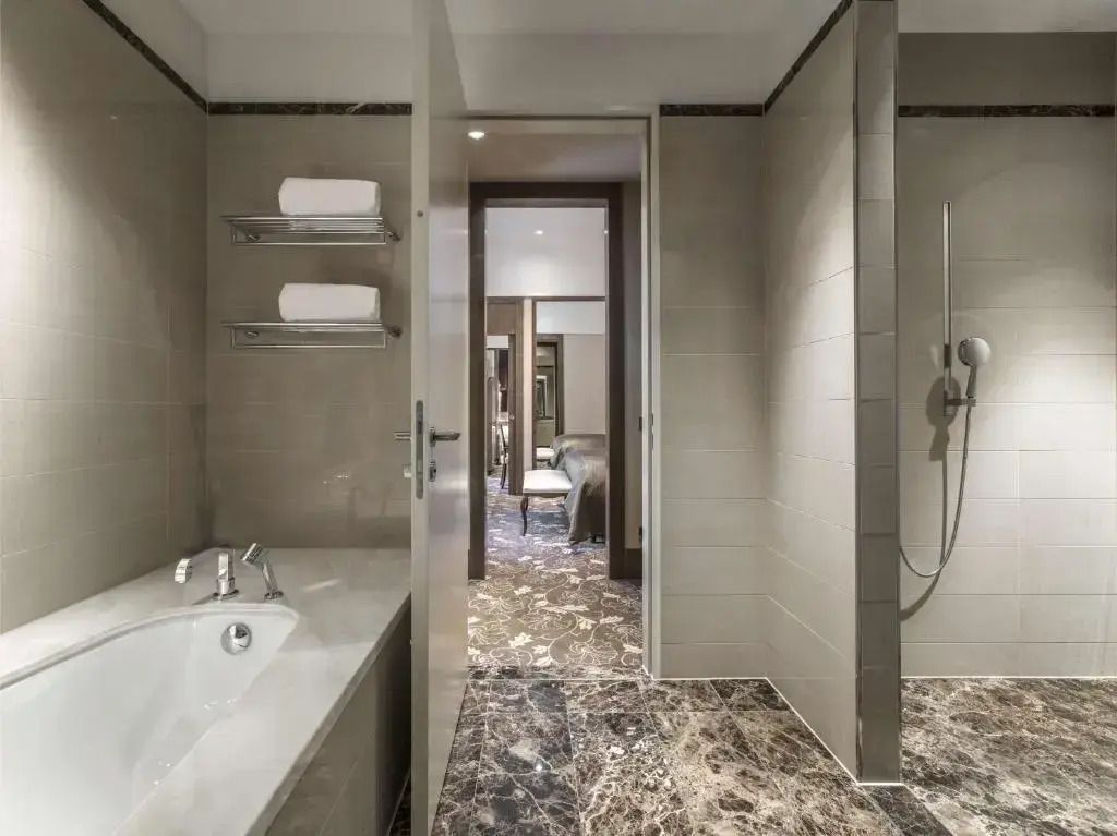 Modernes Badezimmer mit Badewanne und Dusche im Anantara Palais Hansen Vienna Hotel.