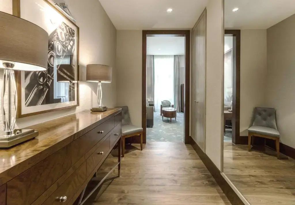 Eleganter Flur der Suite mit Spiegel und Holzmöbeln.