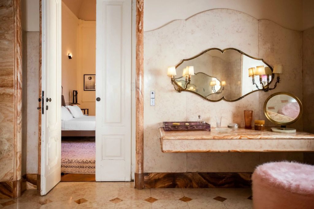 Luxuriöses Badezimmer mit Marmorwaschbecken und stilvollem Spiegel.
