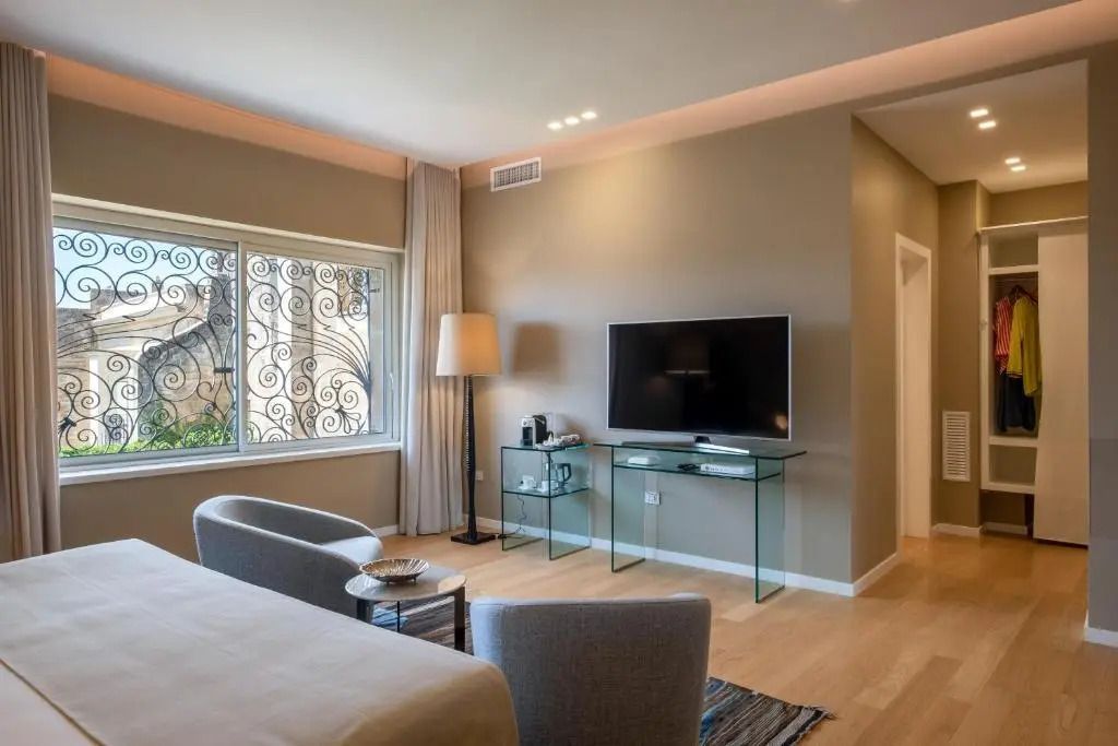 Gemütlicher Wohnbereich der Junior-Suite mit großem Fenster und Fernseher