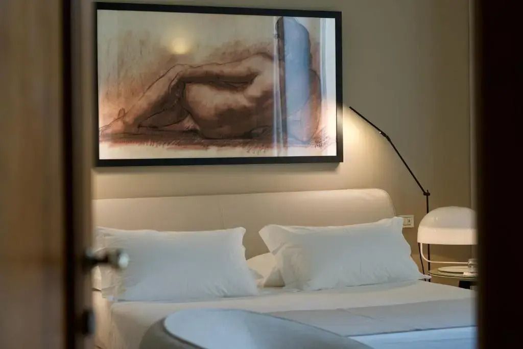 Geräumiges Schlafzimmer in der Junior-Suite mit Kunstwerk über dem Bett
