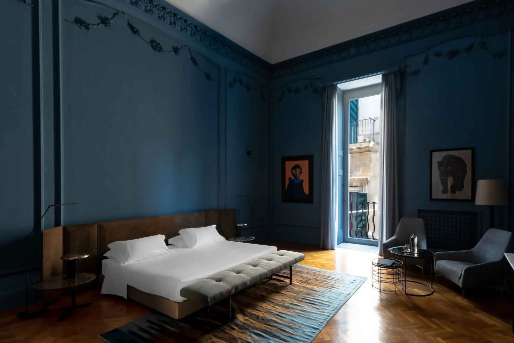 Luxuriöse Suite mit stilvollem Bett und Aussicht auf die Stadt.