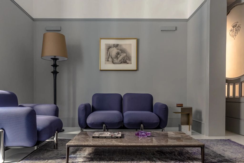 Elegantes Wohnzimmer mit blauen Sofas und Kunst an der Wand in einer Suite.