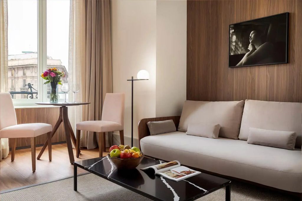 Wohnbereich mit Sofa, Couchtisch mit Früchten und künstlerischem Bild an der Wand