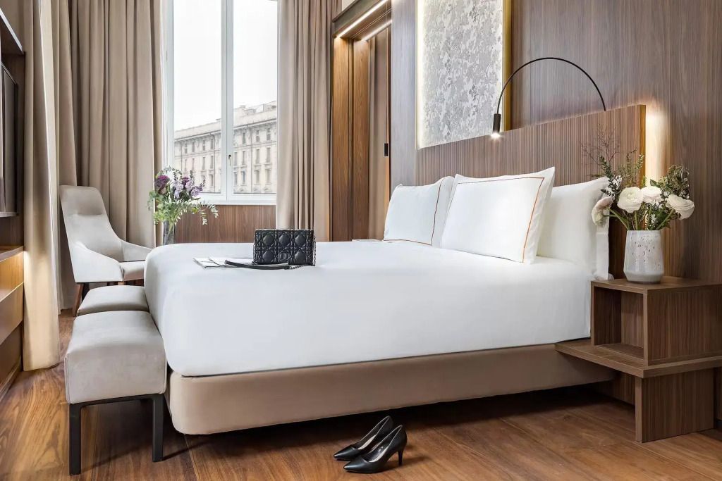 Luxuriöses Doppelbett in eleganter Suite mit Stadtblick und moderner Beleuchtung