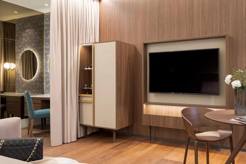 Zimmeransicht mit Holzwänden, großem Fernseher und modernem Schrank