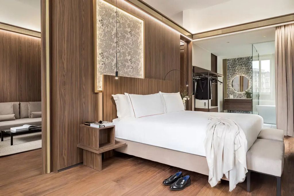 Elegantes Schlafzimmer einer Suite mit Doppelbett, Holzvertäfelung und Designerlampe