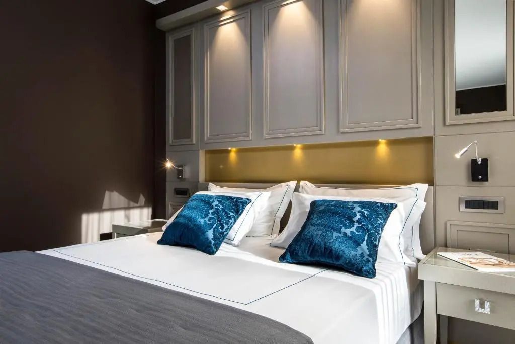 Komfortables Doppelbett mit blauen Zierkissen im klassisch gestalteten Hotelzimmer