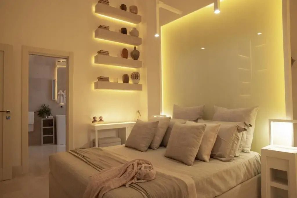 Elegantes Schlafzimmer mit Doppelbett und stilvoll beleuchteten Regalen