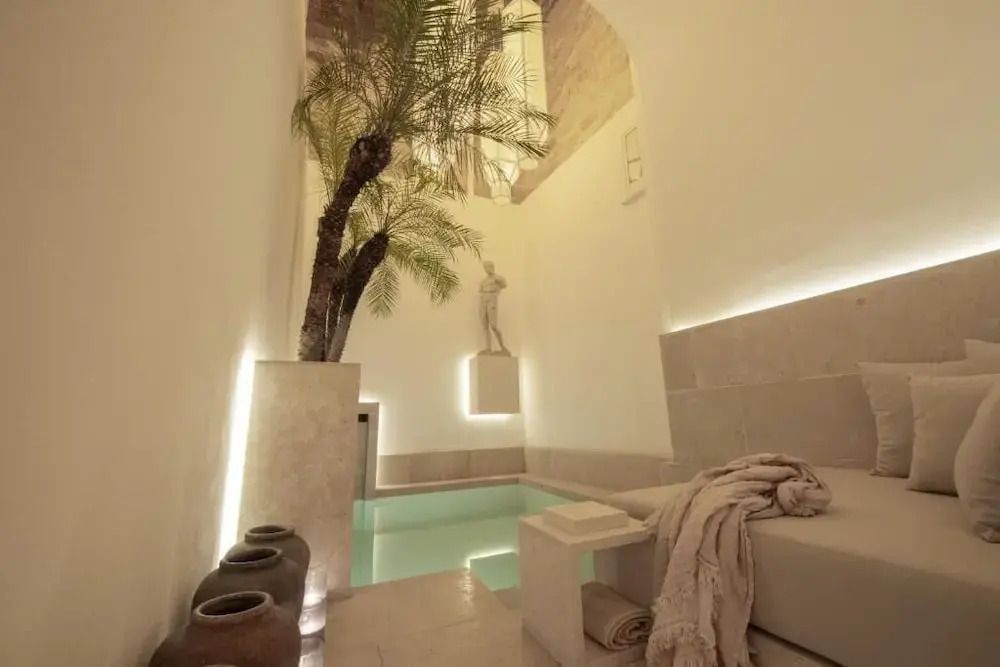 Privater Poolbereich mit Palme und Statue im eleganten Design